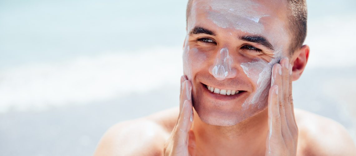 smiling-man-putting-tanning-cream-his-face-takes-sunbath-beach (1)